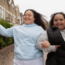 two young adults with developmental disabilities with linked arms skipping through the street in honor of Developmental Disabilities Month
