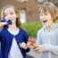 two peers, one with autism, playing with fidget spinners together