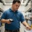 adult male with intellectual disability working at a warehouse where he is scanning and unloading boxes for distribution