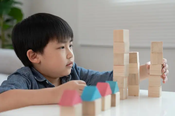 young boy playing building blocks practicing executive functioning skills